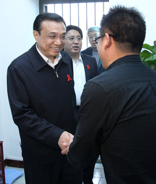 File photo taken on Nov. 18, 2011 shows Li Keqiang (L) shakes hands with an HIV carrier when he inspects AIDS prevention and treatment work in Beijing, capital of China. (Xinhua/Pang Xinglei)