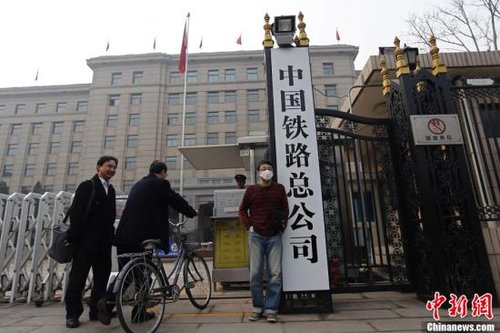 3月17日上午,一名男子在新挂牌的中国铁路总公司牌前留影。当日早上,原“铁道部”牌匾被摘下,工作人员换上了“中国铁路总公司”的新牌。中新社发 张浩 摄