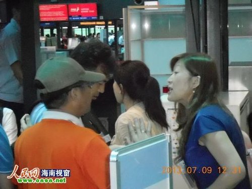 蓝衣女子(图右)在行李托运处大声骂人(图中低头者)