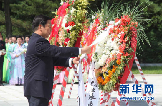 7月26日,国家副主席李源潮在朝鲜桧仓中国人民志愿军烈士陵园整理花圈缎带。新华社记者张利 摄