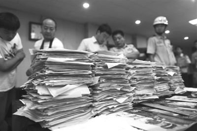 公民个人信息单、推销商品话术单等涉案物品堆成“小山”。昨日,丰台警方通报称,“华夏国博”公司涉嫌利用非法获取的公民个人信息,推销廉价“藏品”,公司299人被拘留。本版摄影/新京报记者 浦峰
