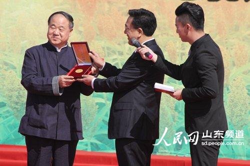 9月26日,山东省高密市委书记范福生赠与2012年诺贝尔文学奖获得者莫言“高密人民勋章”。(摄影 张岩)