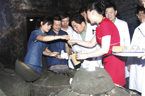 资料图:谷俊山(中)对这坛1902年的老酒很感兴趣。