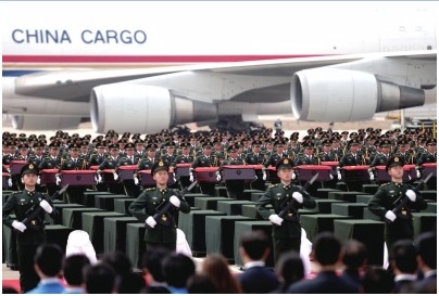 礼兵护送志愿军烈士遗骸棺椁至棺椁摆放区。新华社发