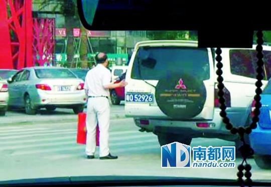 网曝视频中车牌证实为阳江海洋渔业局所属,男子拎礼物进入小区。视频截图