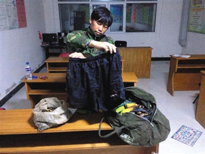 玉山村支部委员会第一个按住逃犯李海伟的村民袁志超展示李海伟被抓获时身上带的东西:短裤、水瓶、土豆玉米等粮食。新京报记者 薛珺 摄