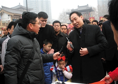 2013年2月6日,陕西省西安市,陕西省书协主席周一波等书法家为市民义务书写春联。图/CFP