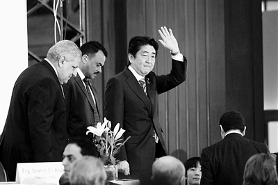 1月17日,在埃及开罗,日本首相安倍晋三在步入埃及-日本商业投资研讨会新闻发布会会场时挥手致意。