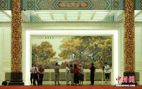 6月20日,人民大会堂布置创作的国画作品《胡杨礼赞》正式亮相金色大厅中央位置。该作品由中央文史研究馆研究员张介宇和陕西省中国画院专职画家张国宏父子合作完成。中新社发 杨可佳摄