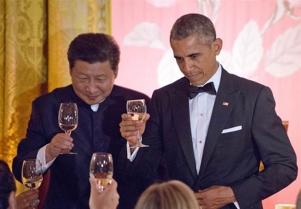 席间，二人向人群举杯。据闻奥巴马为体现亲民，故意将杯子拿错