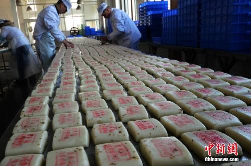资料图:师傅们在把制作好的桂花糖年糕摆放整齐。王思哲 摄